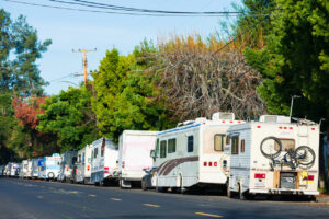 RV, campers and vans long term parked in row on public street.