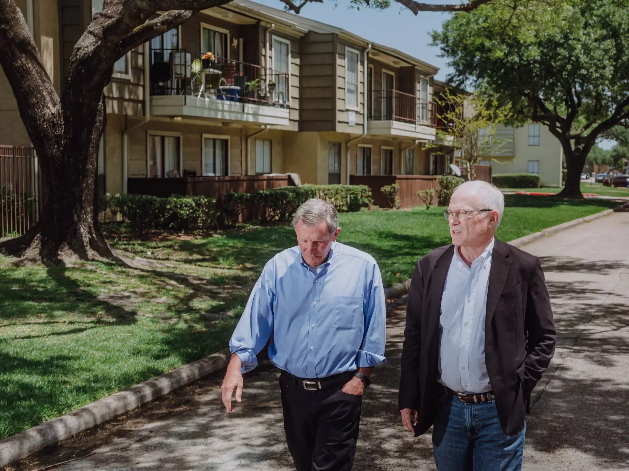 Lance Gilliam and a colleague walk down a street in Houston